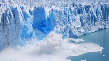Cette image montre un glacier en train de se détacher, avec un énorme bloc de glace s'effondrant dans l'eau.